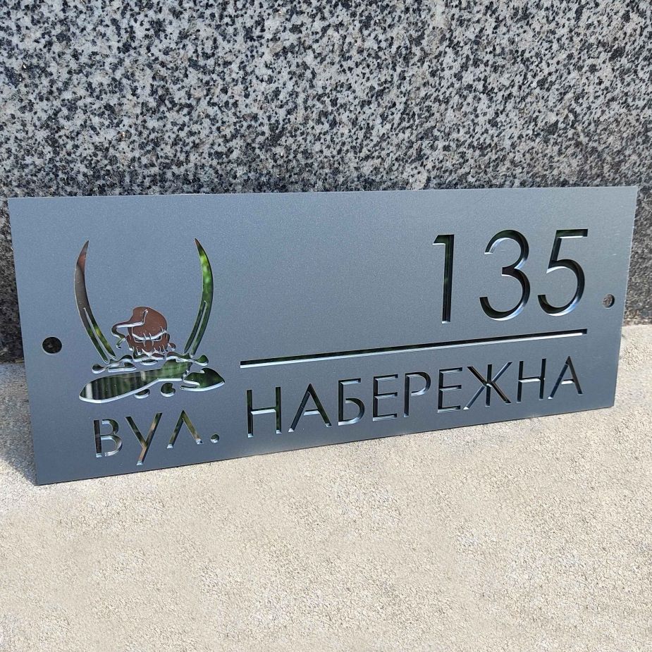 Табличка на хвіртку з адресою будинку