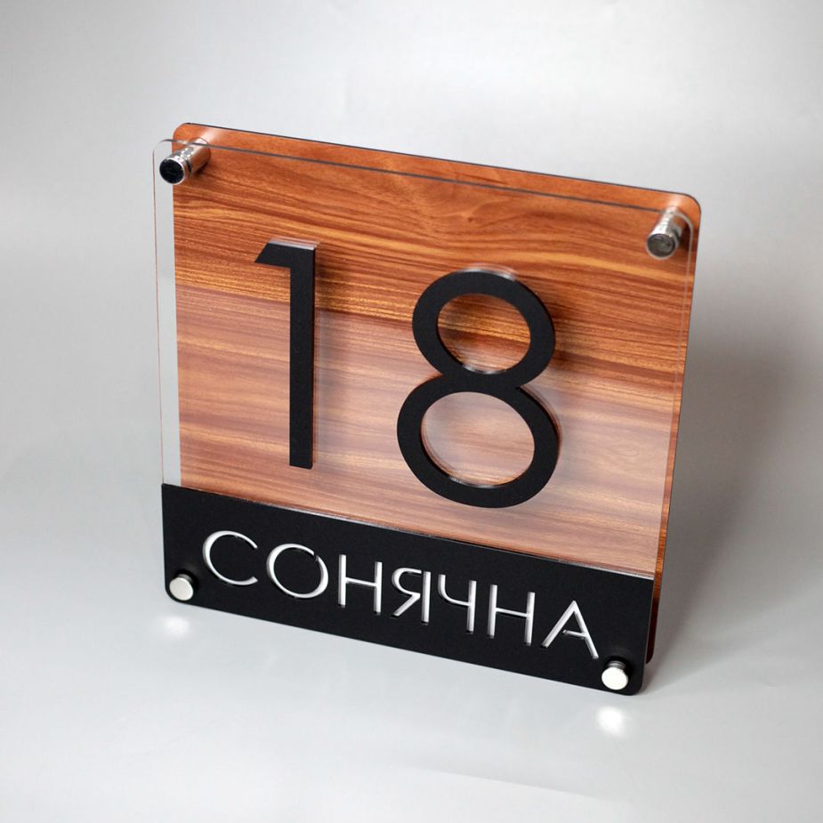 Табличка на хвіртку з адресою будинку
